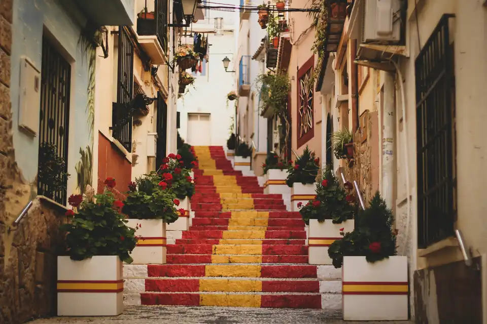 Escadaria de azulejos com vasos de flores numa ruela