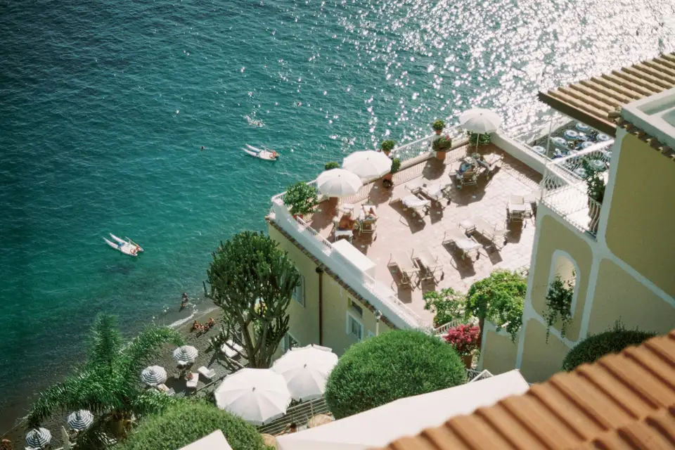 Terraço com guarda-sóis sobre um mar turquesa