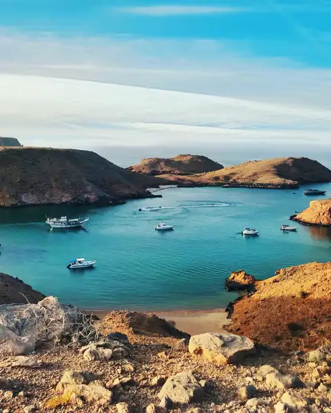 Enseada de água turquesa entre falésias na costa de Omã
