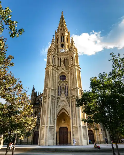 Torre da catedral do Bom Pastor entre árvores, em San Sebastián